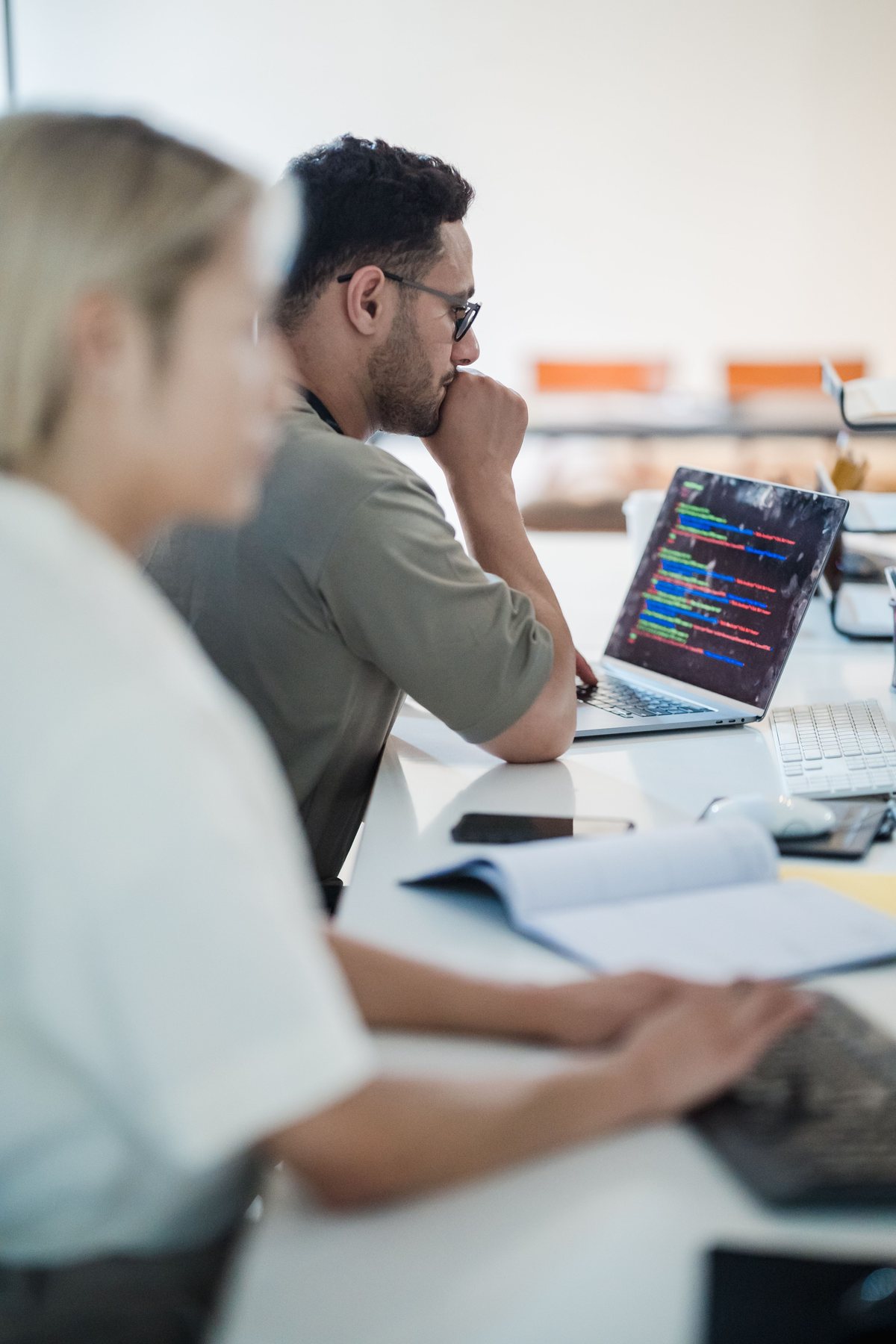 Software developers reviewing code together in a bright office